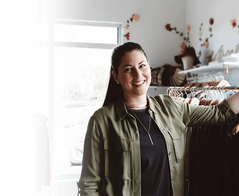 mujer feliz en su tienda de ropa